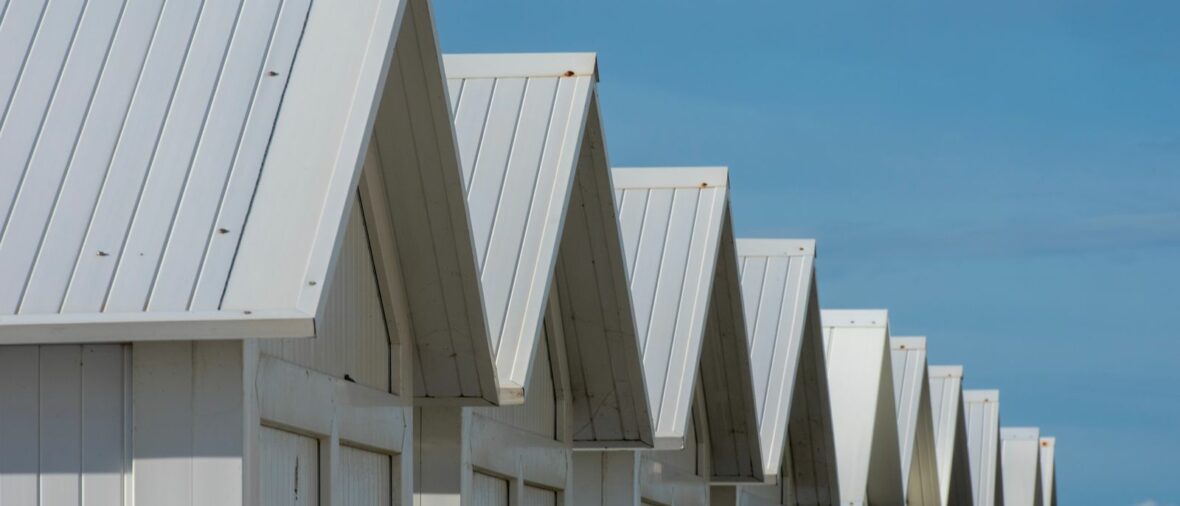 Cabanons de plage blancs illustrant la location saisonnière en 2026