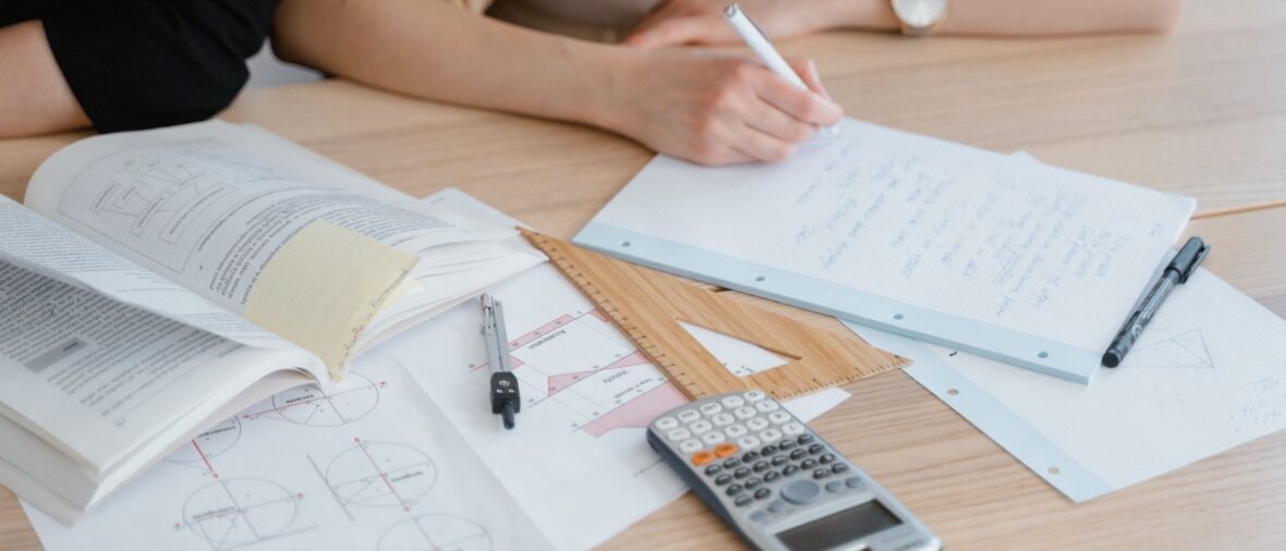 Formation investissement immobilier - deux personnes qui étudient avec livres et calculatrice